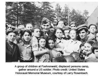 A group of children at Foehrenwald, displaced persons camp, gather around a US soldier